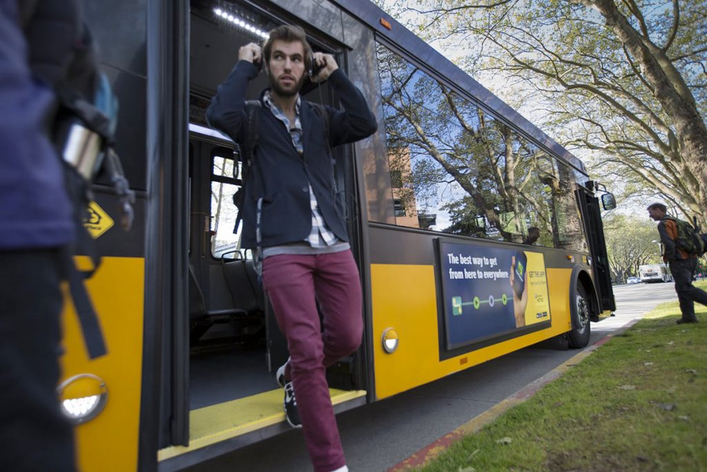 Man stepping off the public pus onto the sidewalk